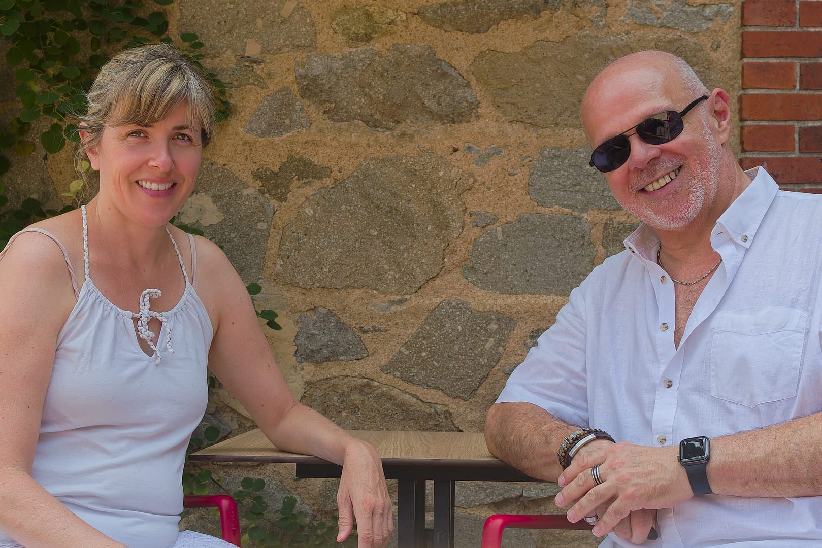 Amandine Thomas et Célio Mattos, duo artistique devant un mur de pierre